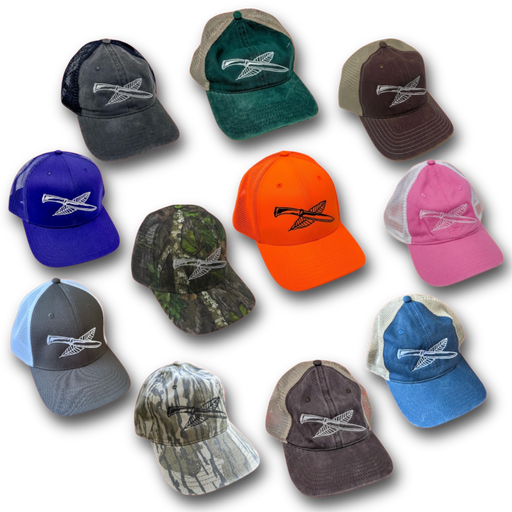 Collection of Nature Reliance School trucker hats in multiple colors, each featuring the embroidered knife and feather logo — camo, blaze orange, blue, pink, green, brown, gray, and black designs for outdoor and survival enthusiasts.
